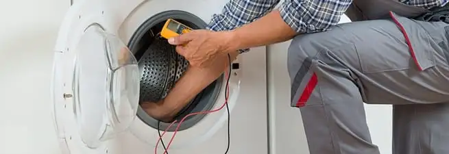 Dryer repair technician inspecting and repairing a clothes dryer in St Paul, MN