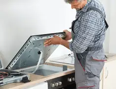 Appliance repair technician installing a built-in cooktop in St Paul, MN