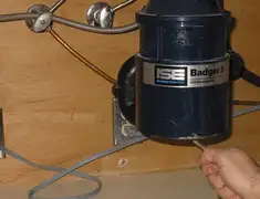 Garbage disposal repair technician tightening the mounting ring under a sink in St Paul, MN