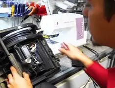 Vacuum repair technician servicing internal components on a workbench in St Paul, MN
