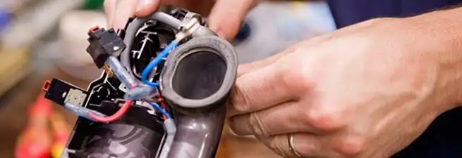 Vacuum repair technician reconnecting wiring and components in St Paul, MN