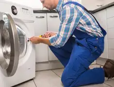 Washing machine repair technician servicing a front-load washer in St Paul, MN