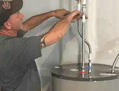 Water heater repair technician tightening supply line connections in St Paul, MN