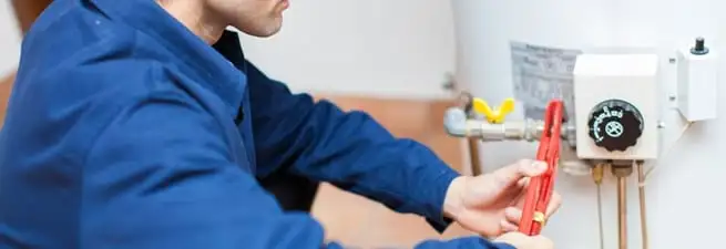 Water heater repair technician adjusting the temperature control and gas valve in St Paul, MN